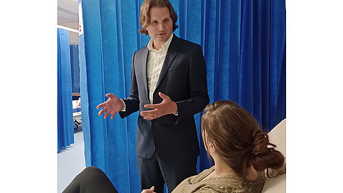 Steff visiting a hospital and speaking to a patient.