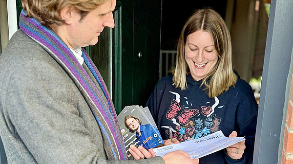 Steff with petition talking to a resident